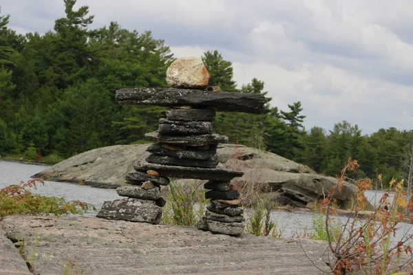 inukshuk rocks lake canadian culture. view at cottage country.
