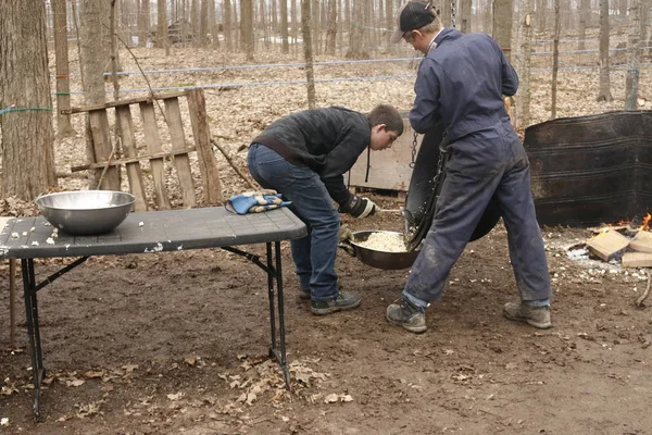 Elmira Canada, april 06 2019: redactionele foto van een Mennonite jongen voorbereiding Popcorn als een display op een ahornsiroop Festival. Het tonen van de traditionele Mennonite manier van koken over brand. — Stockfoto