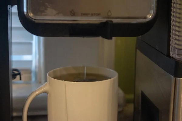 Heißes Wasser in eine Tasse auf schwarzem Hintergrund gießen. — Stockfoto