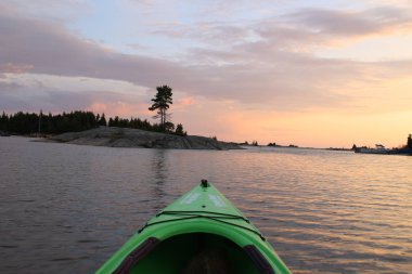 Gün batımında Kano kürek çekmek, güzel Georgan körfezi sularında kano