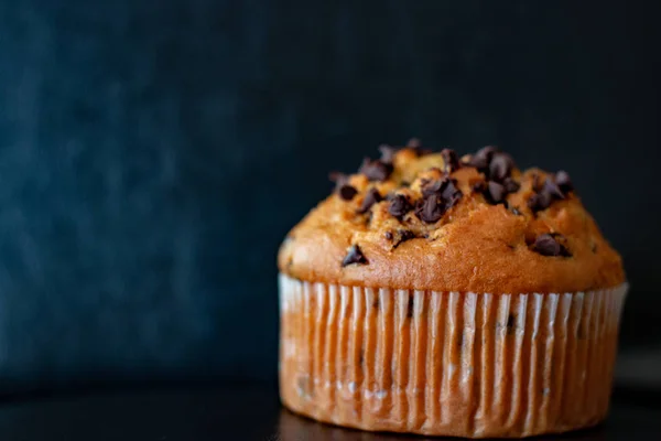 Chocolate Chip Muffin auf schwarzem Hintergrund. Foodfotografie, ungesundes Konzept. — Stockfoto