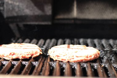 Ateşle barbekü ızgara çiğ burger. Gıda et - ateş ile barbekü ızgara çiğ burger. Sığ dof