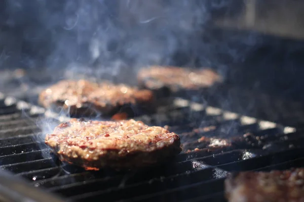 Hamburger ve sosisli alevler ile ızgara üzerinde pişirme — Stok fotoğraf