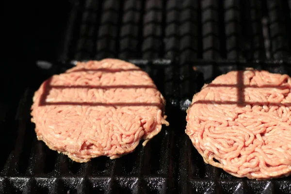 Nyers hamburgerek a grill Barbecue grill kandallóval. Élelmiszer-hús-nyers hamburgerek a grill Barbecue grill kandallóval. Sekély DOF — Stock Fotó