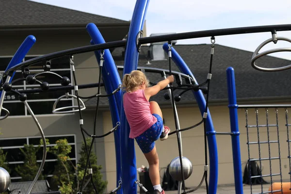 Mała dziewczynka gra na placu zabaw w tematyce parku zabawy i rodziny — Zdjęcie stockowe