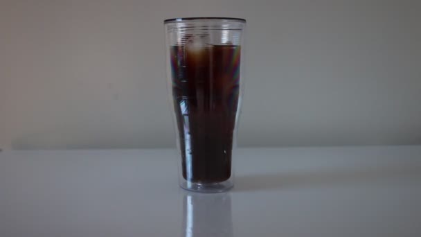 Primer plano de café frío que se vierte en cubitos de hielo con fondo negro. Café frío - Bebida refrescante para veranos que se vierte en un vaso lleno de cubitos de hielo . — Vídeo de stock