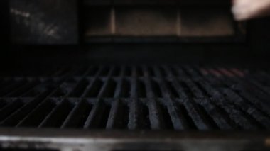 Chef puts a delicious piece of meat on the grill. Tasty meat for a burger cooked on a fiery barbecue grill. Close up of chief cooked very satisfying protein tasty burger in casual bar.