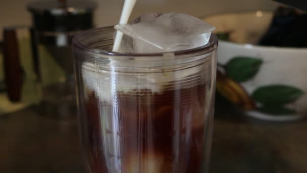 Изготовление холодного кофе со льдом и латте со льдом, водой, молоком и холодным кофе — стоковое видео