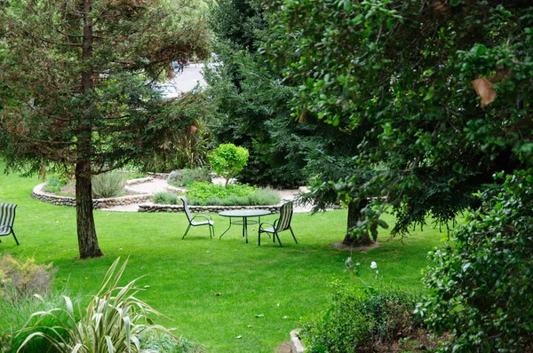Jardim verde do quintal do verão com grama, mesa e cadeiras — Fotografia de Stock