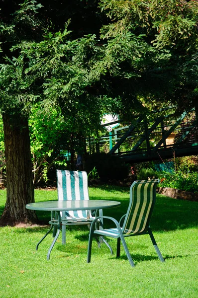 Το καλοκαίρι πράσινο κήπο κατωφλιών με χόρτο, τραπέζι και καρέκλες — Φωτογραφία Αρχείου