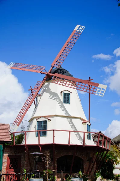 Oude windmolen in het park met blauwe hemel wolken — Stockfoto