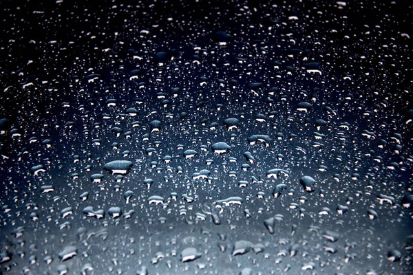 Mavi arka plan üzerinde su damlaları hafif yağmur damlaları.