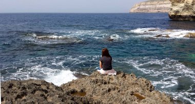 Yalnız bir genç kız deniz sahilinde mesafe içine bakıyor