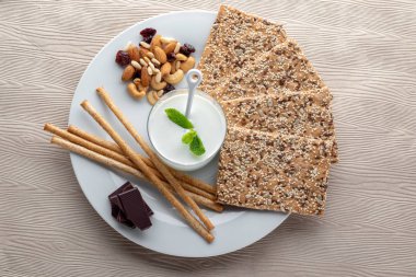 Susam lı kraker ve koyu çikolata ve fındık ile ekmek çubukları ile organik kefir üst görünümü, sağlıklı öğleden sonra diyet snack kavramı  