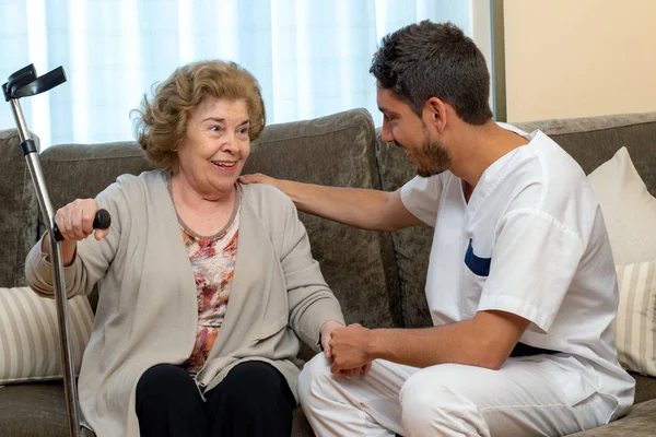 Retrato Cerca Joven Enfermero Conversando Con Una Anciana Sofá Cuidador — Foto de Stock