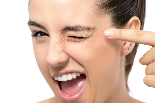 Close up fun portrait of woman pointing with finger at blinked eye.Isolated on white background. — Stock Image Close Fun Portrait Woman Pointing Finger Blinked Eye Isolated White Stock Picture