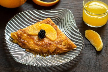 Karamelize edilmiş portakal soslu ince krep tatlısını kapat. Şeffaf tabakta ev yapımı krep suzette..