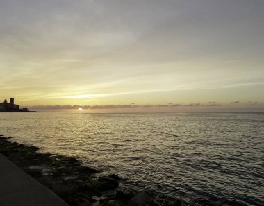 Günbatımı Malecón ve Atlantik Okyanusu üzerinde arka planda - Havana, Küba'da konut bina ile 
