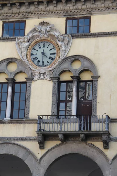 Arquitectura: un reloj entre las ventanas de un edificio — Foto de Stock