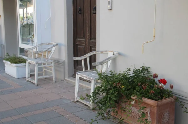 Старі білі дерев'яні стільці і вазони з квітами — стокове фото