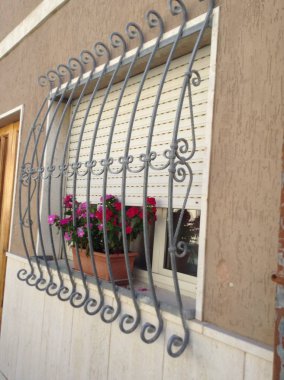 Kırmızı çiçekler ve metal ızgara