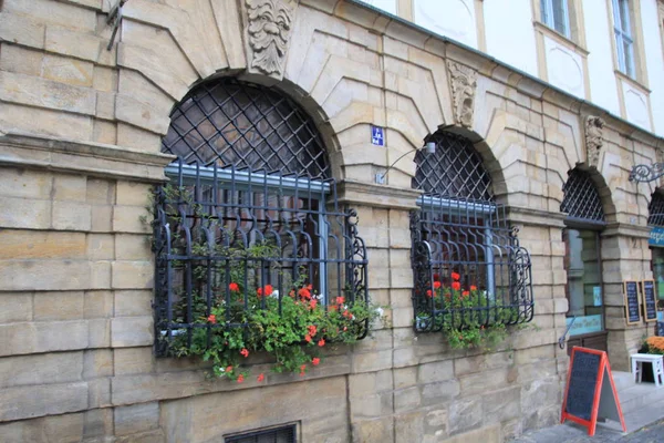 Цветы на окнах с металлическими решетками — стоковое фото