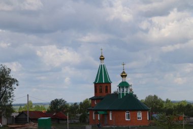 Rusya'da beyaz bulutlar ile mavi gökyüzü altında kırsal kilisenin görünümü