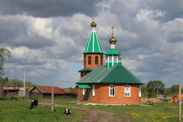 Uitzicht op de landelijke kerk onder de blauwe hemel met witte wolken in Chuvashia — Stockfoto