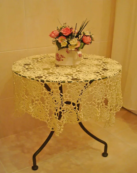 Intérieur fleurs sur une table en métal avec une nappe tricotée — Photo