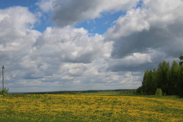 Venkovská krajina s bílými mračny proti modrému nebi. — Stock fotografie