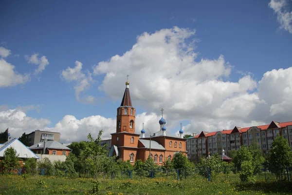 Lente landschap met uitzicht op de kerk onder een blauwe hemel met witte wolken in de stad Kanash, Rusland — Stockfoto