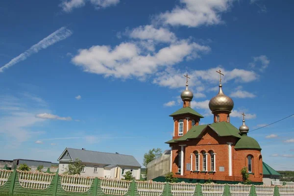 View of the village church under the blue sky with white clouds in the village of New Shaltyama — Stock Photo, Image