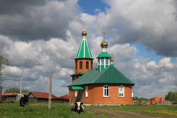 Paesaggio con vista su una chiesa rurale sotto un cielo blu con nuvole bianche a Chuvashia — Foto Stock