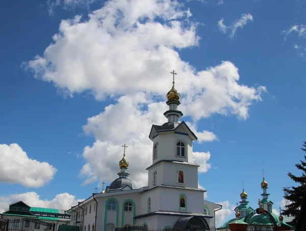 Bílé mraky nad kostelem pod modrým nebem ve městě Kanash, Chuvašia — Stock fotografie