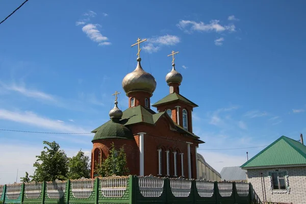 Utsikt över byns kyrka under den blå himlen i byn Novye Shaltyama i Ryssland — Stockfoto