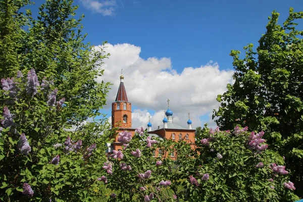 Lente landschap met een bloeiende lila en kerk in de stad Kanash — Stockfoto