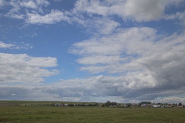 Rusya'da mavi bir gökyüzü ve beyaz bulutlar altında köy manzaralı yaz manzara