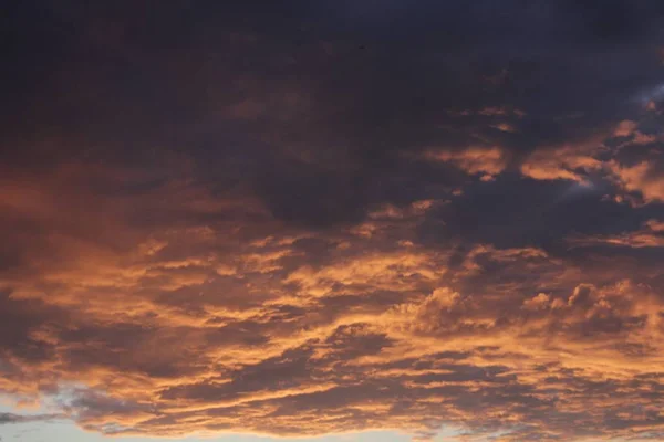 Темно-оранжевый цвет фона - облачная структура неба на закате Стоковое Изображение