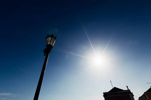 古いランタンと青い空と太陽の背景に建物の部分 — ストック写真