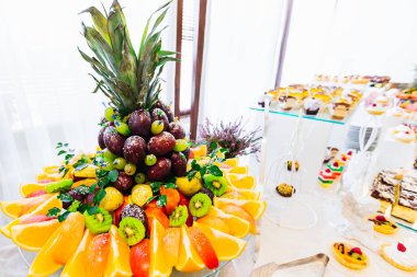 Çikolata lezzetli pasta ve mini kek dilimlenmiş meyve dekore edilmiş