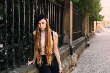 Çit arka plan üzerinde oturan hayret ifadesi ile kız