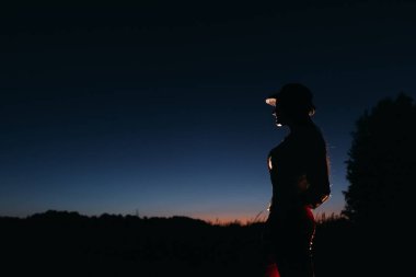 bulutsuz gece gökyüzü ve ağaçlar arka plan karşı kızı silüeti