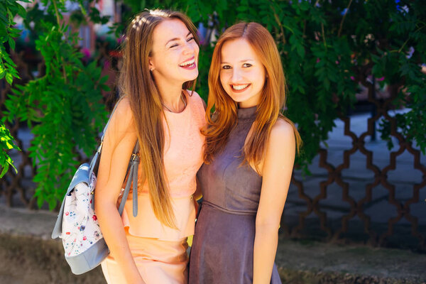 sincere smiles of the best friends having fun time. Close-up of girls in beautiful dresses