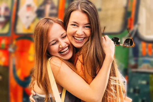 Close Girls Sincere Smiles Faces Hugging Colorful Background — Stock Photo, Image