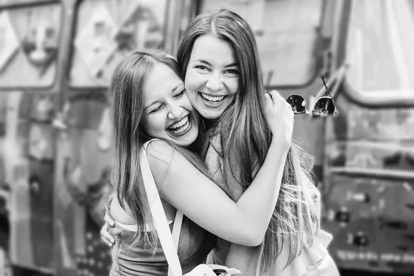 Close Girls Sincere Smiles Faces Hugging Background Painted Bus Black — Stock Photo, Image