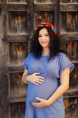 Ellerini onun karnına kapı arka planı tutar bir gelecekte anne bir gülümseme