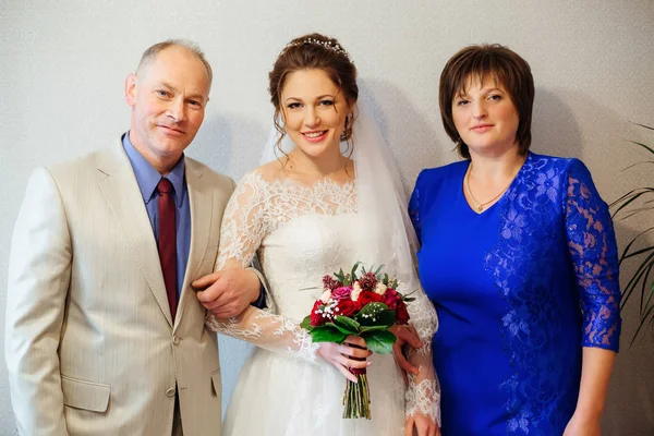 幸福的父母和女儿结婚 穿着婚纱和花束在她的手 — 图库照片