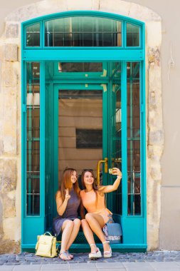 güzel kızlar merdivenlerde oturan cam kapı yakınındaki ve selfie yapmak