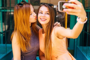 iki kız selfie yapmak, bir tanesi gözleri kapalı ve onun arkadaşı öpmek ister