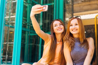 güzel kızların kendilerini cam vitrinler arka plan üzerinde fotoğrafı orijinal gülümsüyor